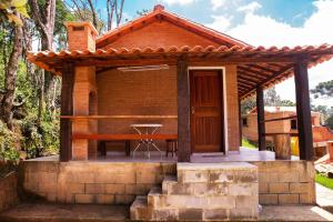 a small house with a porch with a table at Chale com lazer completo em Lima Duarte MG in Conceição da Ibitipoca