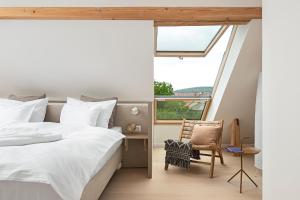 乔保克Buborék的一间卧室，里面有一张床、一把椅子和一扇窗户。