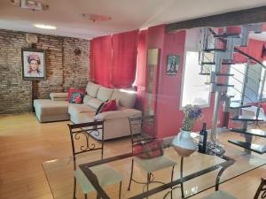 a living room with red walls and a spiral staircase at Duplex Revellín Frida Home AIRE ac in Logroño