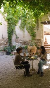 two people sitting at a table with wine glasses at Casa Rural Hípica Molí categoria superior in Rosell