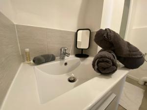 ein weißes Waschbecken mit Handtüchern und einem Spiegel in der Unterkunft Mini studio 9m2 - 027 in Rouen