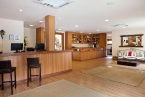 a large lobby with a bar with chairs and a counter at Hotel Fazenda Suica Le Canton in Teresópolis
