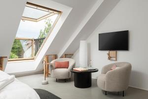 a attic bedroom with two chairs and a tv at Buborék in Csopak