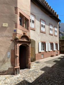 un viejo edificio con una puerta delante en Logement de charme dans un monument historique daté de 1544, au centre de Haguenau, en Haguenau