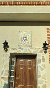 ein Gebäude mit einer Holztür und zwei Lichtern in der Unterkunft Casa Rural Baños del Rey con piscina climatizada in Vega de Santa María
