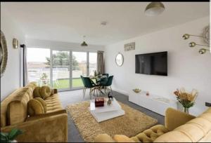 a living room with a couch and a tv and a table at Penthouse Luxury Apartment in Dagenham
