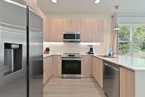 a kitchen with stainless steel appliances and a microwave at New Spacious&Tranquil Townhouse near Disney in Orlando