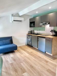 uma cozinha com um sofá azul num quarto em LE QUAI 5 - Studio NEUF CALME - CLIM - WiFi - Gare à 200m em Agen