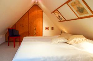 ein Schlafzimmer mit einem weißen Bett im Dachgeschoss in der Unterkunft Haus Wexler 4 - OG in Cuxhaven