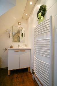 ein Bad mit einem Waschbecken und einem Spiegel in der Unterkunft Haus Wexler 4 - OG in Cuxhaven