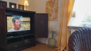 a television in a wooden entertainment center in a living room at Haus Wexler 5 - OG in Cuxhaven