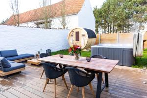 a patio with a wooden table and chairs on a deck at La Grenouille - Suite de luxe & Welness Privatif in Leuze-en-Hainaut
