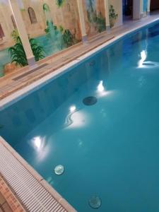 a large blue swimming pool with lights in it at Apartament Małgosi in Malbork