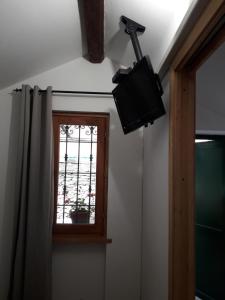 baño con ventana y TV en la pared en La casetta, en Varazze