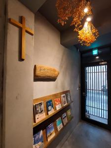 una habitación con una cruz y libros en la pared en 以樂以樂 en Lugang