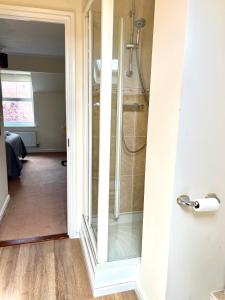 a bathroom with a shower and a glass door at Beautiful 3-bedroom house, city centre, parking in Norwich