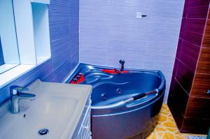 a bathroom with a blue tub next to a sink at CRISPAN SUITES & EVENT CENTRE in Jos
