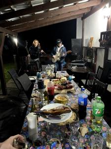 a long table with food and two people playing music at Dom Supełek in Duszniki Zdrój