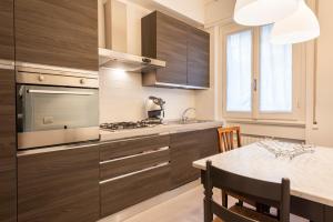 フィレンツェにあるPonte Vecchio Luxury Suiteのキッチン(木製キャビネット、ダイニングルーム付きのテーブル付)