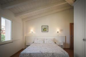 a white bedroom with a bed and a window at Sanctuary Armony in Bono