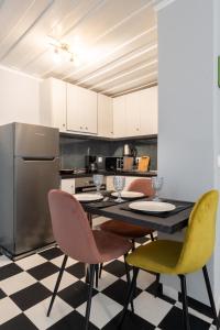 a kitchen with a table with chairs and a refrigerator at Spianada Collection of Studios & Apartments by Konnect in Corfu Town