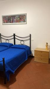 a bedroom with two blue beds and a wooden dresser at Appartamenti Podere 270 in Punta Ala