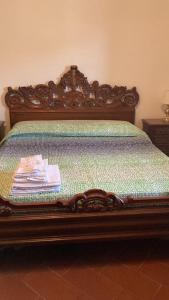 un letto con testiera in legno e una pila di vestiti di Appartamenti Podere 270 a Punta Ala