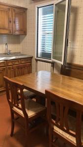 a kitchen with a wooden table and two chairs at Appartamenti Podere 270 in Punta Ala