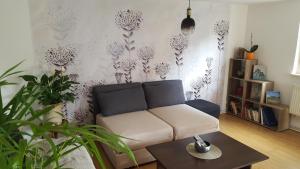 a living room with a couch and some plants at Maison à colombage La Houblonnière in Oberbetschdorf