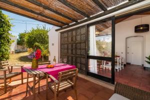 een eetkamer met een tafel en stoelen op een terras bij Casas Barulho - Villa Jacaranda A8 in Albufeira