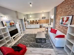 a living room with a white couch and a brick wall at Red&Yellow Apartments Centrum in Olsztyn
