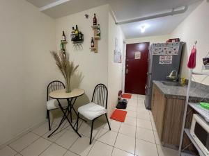 a kitchen with a table and chairs and a refrigerator at Urban Deca Homes Manila Rustic Cozy Staycation in Manila