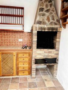 cocina con chimenea de piedra en una habitación en lujosa villa con piscina privada en Puerto de la Cruz