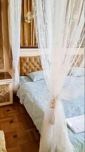 a bedroom with a bed with curtains on it at Classic Apartment on Kievyan in Yerevan