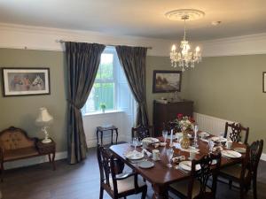 uma sala de jantar com uma mesa com cadeiras e uma janela em Entire Farmhouse in Tipperary em Nenagh