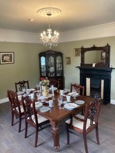uma sala de jantar com uma mesa e cadeiras e um lustre em Entire Farmhouse in Tipperary em Nenagh