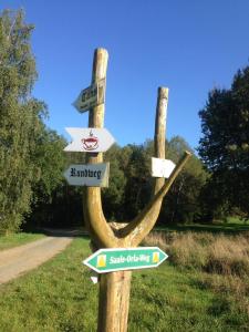 a wooden sign with arrows on a road at Tiny House - Auszeit im Wald am Badesee in Tanna