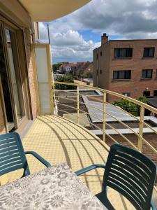 a patio with a table and chairs on a balcony at Fiets & Zee - Bike & Sea in Ostend