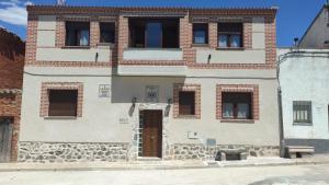 ceglany budynek z drzwiami i oknami w obiekcie Casa Rural Baños del Rey con piscina climatizada w mieście Vega de Santa María