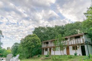 una casa con dos sillas blancas delante en Tacuifi II - Duplex en Los Reartes