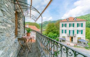 un balcón con mesa y silla y un edificio en Pet Friendly Home In Loco Di Rovegno With House A Panoramic View, en Carchelli