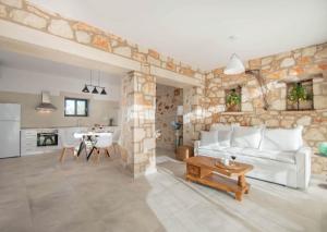 a living room with a white couch and a stone wall at Villa Dionisis in Laganas