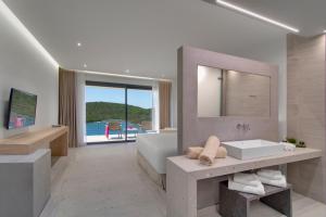 a bathroom with a tub and a sink and a mirror at Sivota Deamaris Luxury Boutique Hotel in Syvota