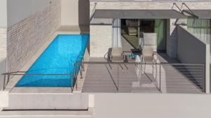 a swimming pool in a house with two chairs at Sivota Deamaris Luxury Boutique Hotel in Syvota