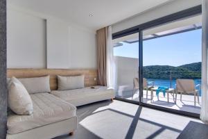 a living room with a couch and a view of the ocean at Sivota Deamaris Luxury Boutique Hotel in Syvota