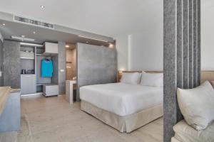 una camera con un grande letto bianco e un divano di Sivota Deamaris Luxury Boutique Hotel a Sivota