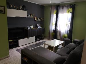 sala de estar con sofá y TV en Apartamento Duartes en Barbastro vistas al pirineo en Barbastro