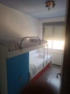 Etagenbett in einem kleinen Zimmer mit Fenster in der Unterkunft Apartamento Duartes en Barbastro vistas al pirineo in Barbastro