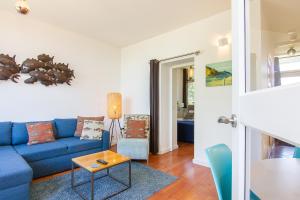 een woonkamer met een blauwe bank en een tafel bij Appartement De Zeemeermin, Free parking in Zandvoort +21 foto's