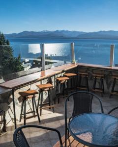 a bar with chairs and tables and a view of the water at Tangoinn Hostel Downtown in San Carlos de Bariloche